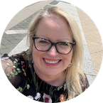 Photo of board member with long blonde hair and black glasses