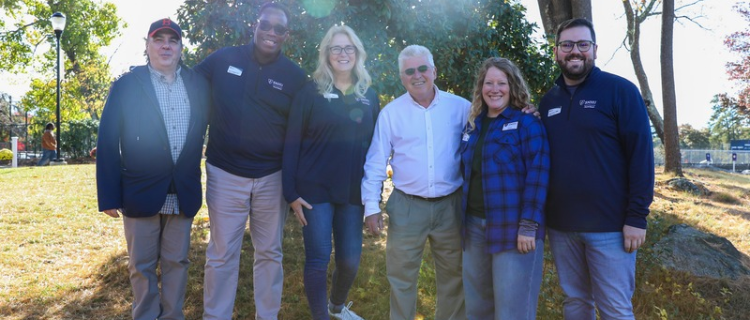 group of alumni board members outside smiling in group photo