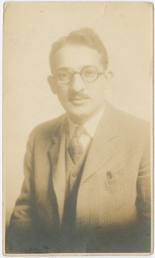 Portrait of man wearing glasses, coat, and tie