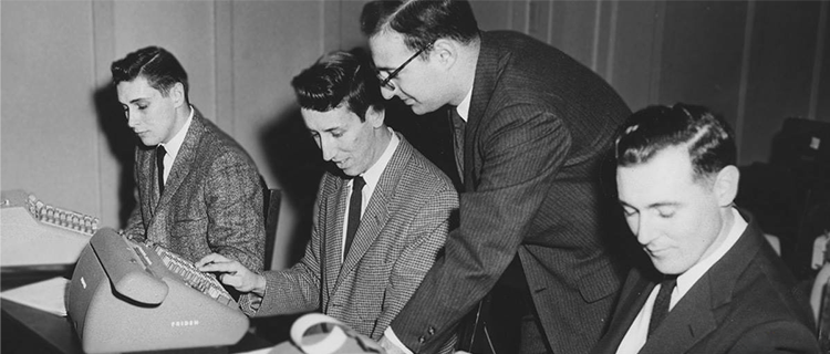 Black and white photo of teacher assisting students