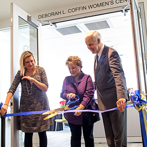 Group of people cut ribbon in front of space named Deborah L. Coffin Women's Center