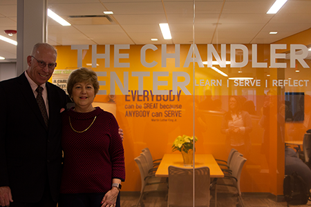 Two people stand in front of window that reads The Chander Center