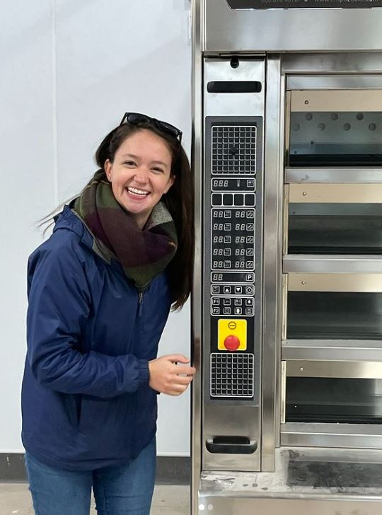 Marissa smiling and posing next to oven