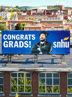 Billboard atop a SNHU building that reads 'Congrats Grads!'