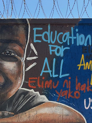 Mural on cement wall that says "Education for All"