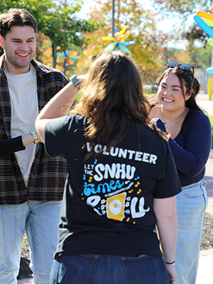 Volunteer chatting with a couple other folks at the 2024 Homecoming street fair